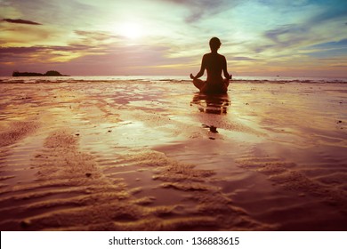 Yoga And Fitness, Silhouette Of Woman Meditating On The Beach
