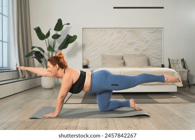 Yoga fitness workout training. Woman practicing yoga at home. Plus size female doing sports exercise on yoga mat indoor. Girl in sportswear have training workout for weight loss. Sport and fitness - Powered by Shutterstock