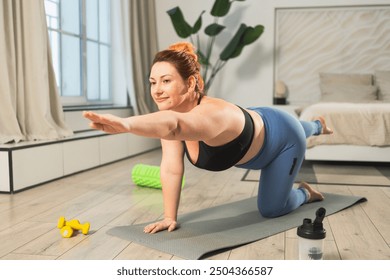 Yoga fitness workout training. Woman practicing yoga at home. Plus size female doing sports exercise on yoga mat indoor. Girl in sportswear have training workout for weight loss. Sport and fitness - Powered by Shutterstock