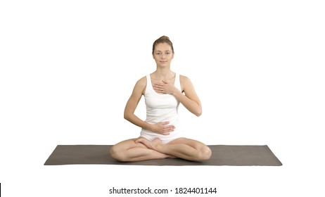 Yoga girl breathing in lotus pose with her hands on her stomach and chest on white background. - Shutterstock ID 1824401144