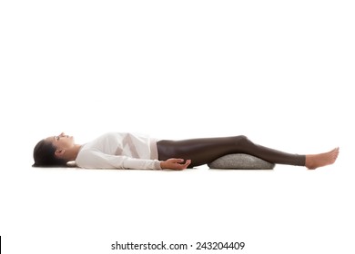 Yoga Girl On White Background Lying In Shavasana (Savasana, Corpse Pose)