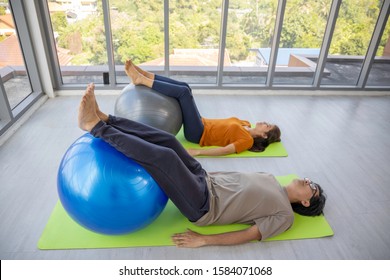 Yoga group, exercise Sport Health care Lifestyle National physical Fitness concept. Senior Asian couple workout together. Men and women lie on the mat yoga Legs put on exercise balls - Powered by Shutterstock