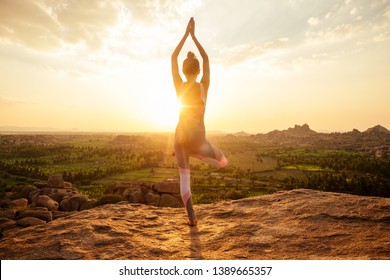 Yoga in Hampi temple copyspase at sunset.travel vacation copy spase lady with stylish jumpsuit