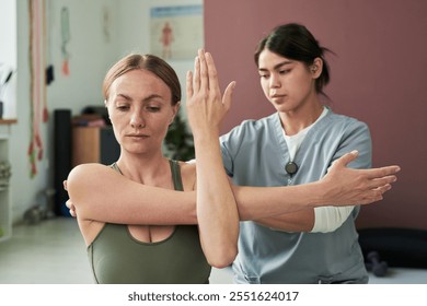 Yoga instructor guiding student through a stretching exercise in a fitness studio. Demonstrating proper techniques for improving flexibility and posture - Powered by Shutterstock