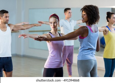 Yoga Instructor Helping Student With A Correct Pose In Fitness Studio