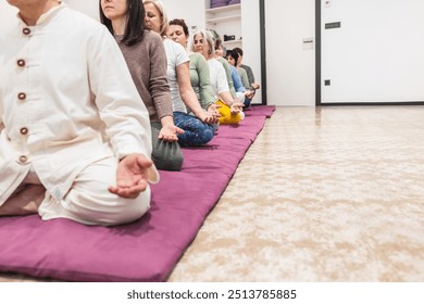 A yoga instructor leads senior women in a seated meditation session, focusing on mindfulness and calmness. Concept of spiritual balance, relaxation, and group practice. - Powered by Shutterstock