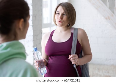 Yoga Instructor Talking To Pregnant Female Yoga Student