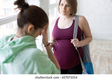 Yoga Instructor Talking To Pregnant Female Yoga Student