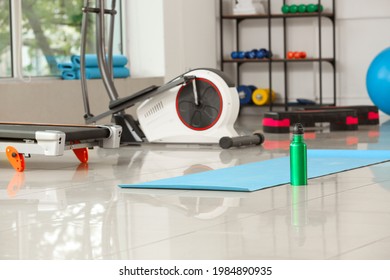 Yoga Mat And Bottle Of Water On Floor In Gym