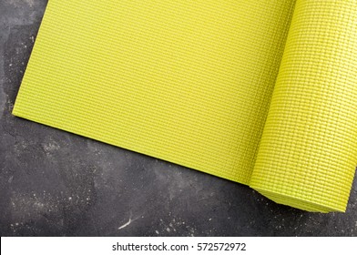 Yoga mat on dark background. Equipment for yoga. Concept healthy lifestyle, sport and diet. Copyspace. Selective focus