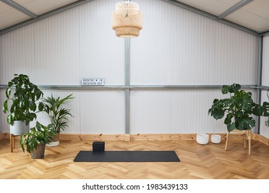 yoga mat on wooden floor in a fitness center or at home, industrial style and modern. comfortable space for doing sport exercises, meditating, pilates, yoga equipment.