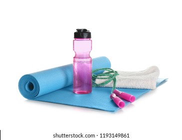Yoga mat with towel, jumping rope and bottle of water on white background - Powered by Shutterstock