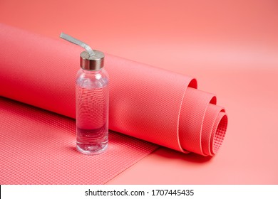 Yoga Mat With Water Bottle On Pink Background. Equipment For Yoga And Meditation. Healthy Lifestyle Concept.  Home  Workout.