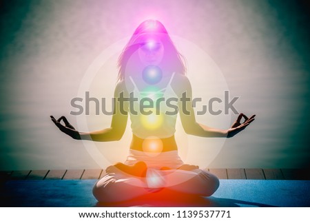Yoga meditation hands woman in yoga lotus pose with seven chakras, aura, spiritual and Yin Yang symbols, balancing your life in nature concept.