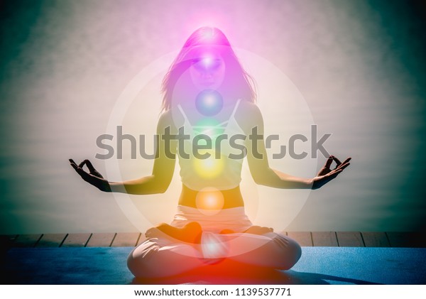 Yoga meditation hands woman in yoga lotus pose\
with seven chakras, aura, spiritual and Yin Yang symbols, balancing\
your life in nature\
concept.