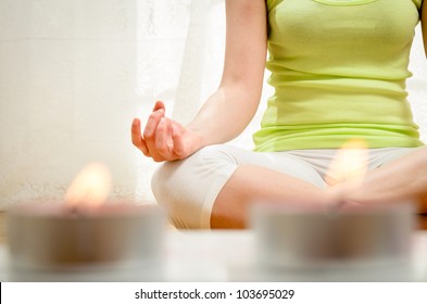 Yoga Meditation At Home. Relax Concept With Unrecognizable Spiritual Young Woman Sitting In Front Of Candles. Caucasian Concentrating Model. Copyspace.