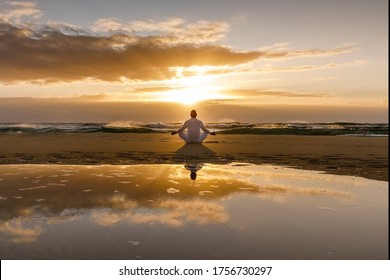 yoga meditation silhouette lotus sunrise beach, mindfulness, wellness and wellbeing concept, water reflection of man in yoga lotus pose sitting alone on sand with ocean cloud background, copy space - Shutterstock ID 1756730297