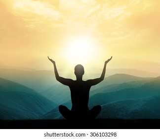 Yoga and meditation. Silhouette of man in mountains.