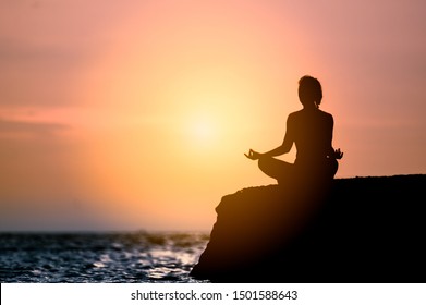 Yoga Meditation Silhouette Young Woman On The Beach At Sunset.