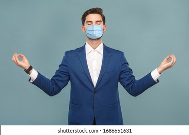 Yoga and meditation. young calm man with surgical medical mask standing and relaxing. Business people medicine and health care concept. Indoor, studio shot on light blue background - Powered by Shutterstock