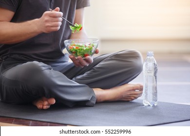 Yoga men with a bowl of vegetable salad, a bottle of water wearing a sportive outfit. Healthy lifestyle concept, close up - Powered by Shutterstock