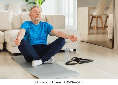 Yoga mindfulness meditation. Senior adult mature man practicing yoga at home. Mid age old grandfather sitting in lotus pose on yoga mat meditating relaxing. Older man doing breathing practice - Powered by Shutterstock