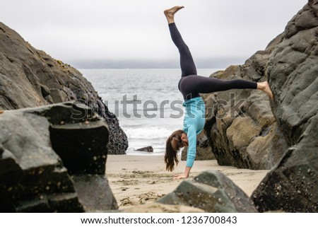 Yoga on the beach with a beautiful, brunette, strong women in San Francisco near the Golden Gate bridge on a California beach.