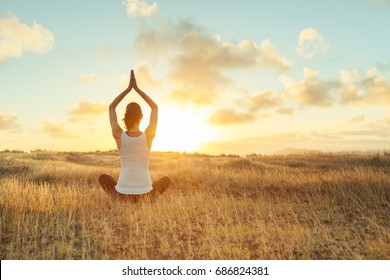 Yoga Outdoor. Happy Woman Doing Yoga Exercises. Yoga Meditation In Nature. Concept Of Healthy Lifestyle And Relaxation. Woman Practicing Yoga On The Grass