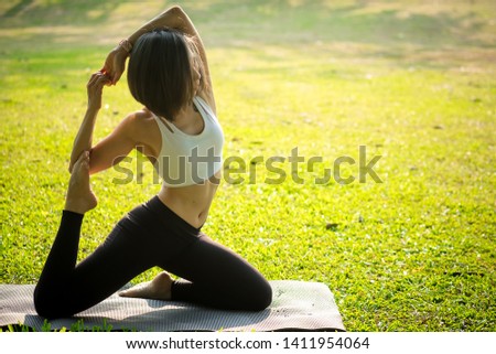 Yoga in the park, young women practicing yoga in the morning . Yoga outdoor. Concept of healthy lifestyle and relaxation. Meditation in nature.Healthy fitness lifestyle concept.