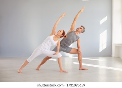 Yoga people in sportswear are practicing yoga in a bright classroom. - Powered by Shutterstock