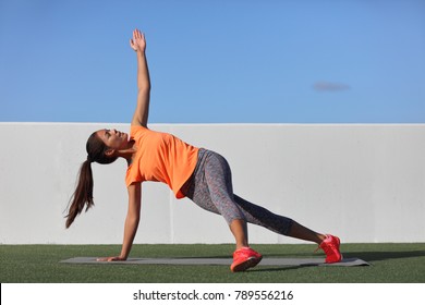 Yoga Pose Variation Fitness Girl Doing The Fallen Triangle Assited With Leg. Asian Woman Doing Side Plank With Lateral Leg Raise. Planking Exercise For Body Core, Bodyweight Workout At Home Gym.