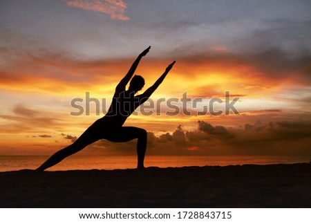 Yoga Poses. Woman Practicing Side Angle Asana On Ocean Beach. Female Silhouette Standing In Parivrtta Parsvakonasana At Beautiful Sunset. Yoga As Exercise For Lifestyle.