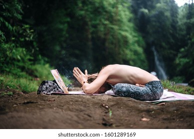 Yoga practice and meditation in nature. Man practicing near river.