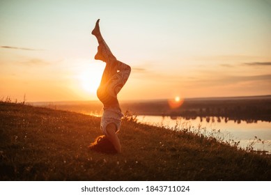 Yoga practice and meditation in nature in sunrise. Woman practicing near big river Kama - Shutterstock ID 1843711024
