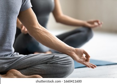 Yoga session process meditation practice close up focus on male fingers folded in mudra symbol. Concept of clarity of mind, improve inner balance, healthy lifestyle, serenity, internal calmness state