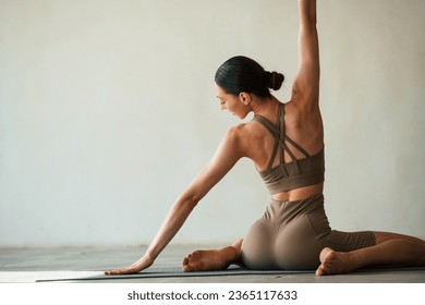 Yoga session. Young woman with slim body type is in fitness clothes in the studio. - Powered by Shutterstock