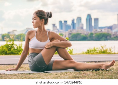 Yoga Stretch Exercise Fit Asian Woman Stretching Lower Back For Spine Health On City Outdoor Fitness Class In Park. Seated Spinal Twist.