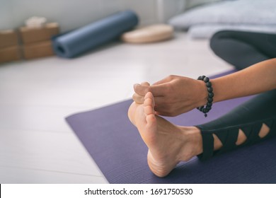 Yoga Stretching At Home Girl Stretches Big Toe Pull Stretch Exercises Woman Doing Hamstring Warm Up At Home On Fitness Mat Training Stretching Legs Wearing Mala Bracelet.