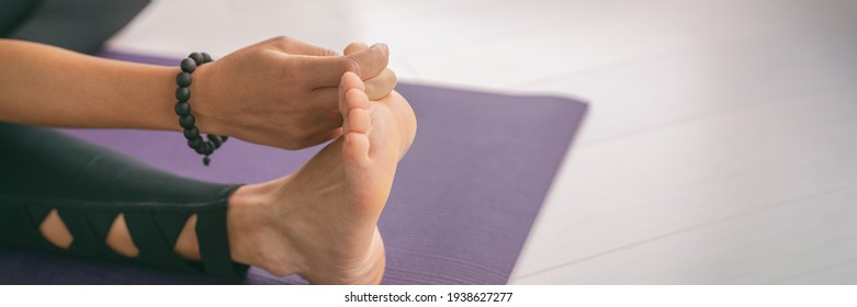 Yoga Stretching At Home Girl Stretches Big Toe Pull Stretch Exercises Woman Doing Hamstring Warm Up At Home On Fitness Mat Training Stretching Legs Wearing Mala Bracelet. Panoramic Crop.