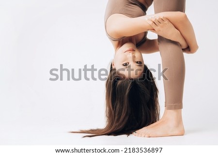 Yoga, stretching workout background with copy space. Beautiful yogi asian girl showing a perfect flexibility. Korean woman hugging her knees without bending them. Healthy and sporty lifestyle concept.