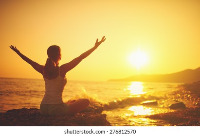 yoga at sunset on the beach. woman doing yoga, performing asanas and enjoying life on the sea