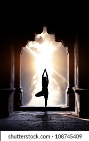 Yoga Vrikshasana Tree Pose By Man Silhouette In Old Temple Arch At Dramatic Sunset Sky Background. Free Space For Text