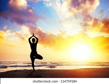 Yoga Vrikshasana Tree Pose By Woman In Silhouette With Sunset Sky Background. Free Space For Text