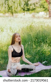 Yoga Woman On Green Grass Girl Relaxes In The Field. Yoga Woman In Green Park Girl Doing Gymnastics Outdoors. Meditating Woman In Meditation In Yoga Pose Practices Outdoors