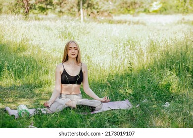 Yoga Woman On Green Grass Girl Relaxes In The Field. Yoga Woman In Green Park Girl Doing Gymnastics Outdoors. Meditating Woman In Meditation In Yoga Pose Practices Outdoors