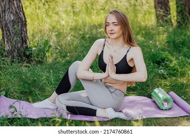 Yoga Woman On Green Grass Girl Relaxes In The Field. Yoga Woman In Green Park Girl Doing Gymnastics Outdoors. Meditating Woman In Meditation In Yoga Pose Practices Outdoors