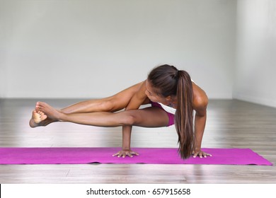 Yoga Woman Strength Training On Exercise Mat Doing Yoga Poses Exercises At Gym. Difficult Pose, Astavakrasana, Asymmetrical Arm Balance Eight Angle Pose.