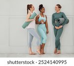 Yoga, women and conversation with gym mat at wellness, health and pilates studio with friends. Happy, smile and chat with training and fitness fashion with bottle and exercise gear with diversity