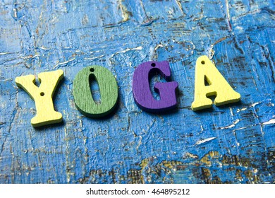 Yoga word made of wooden colorful letters on vintage background