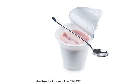Yoghurt flavored strawberry in an open plastic Cup with a beautiful elegant spoon isolated on a white background.